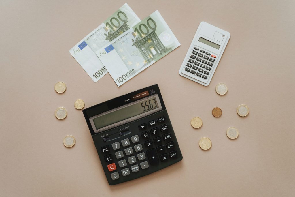 Vorweggenommene Erbfolge: Taschenrechner mit Geld auf dem Tisch steht symbolisch für Erbschaftsteuer